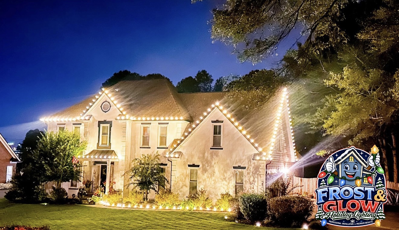 Warm-white roofline and landscape lighting photographed at blue hour on a stucco two-story.