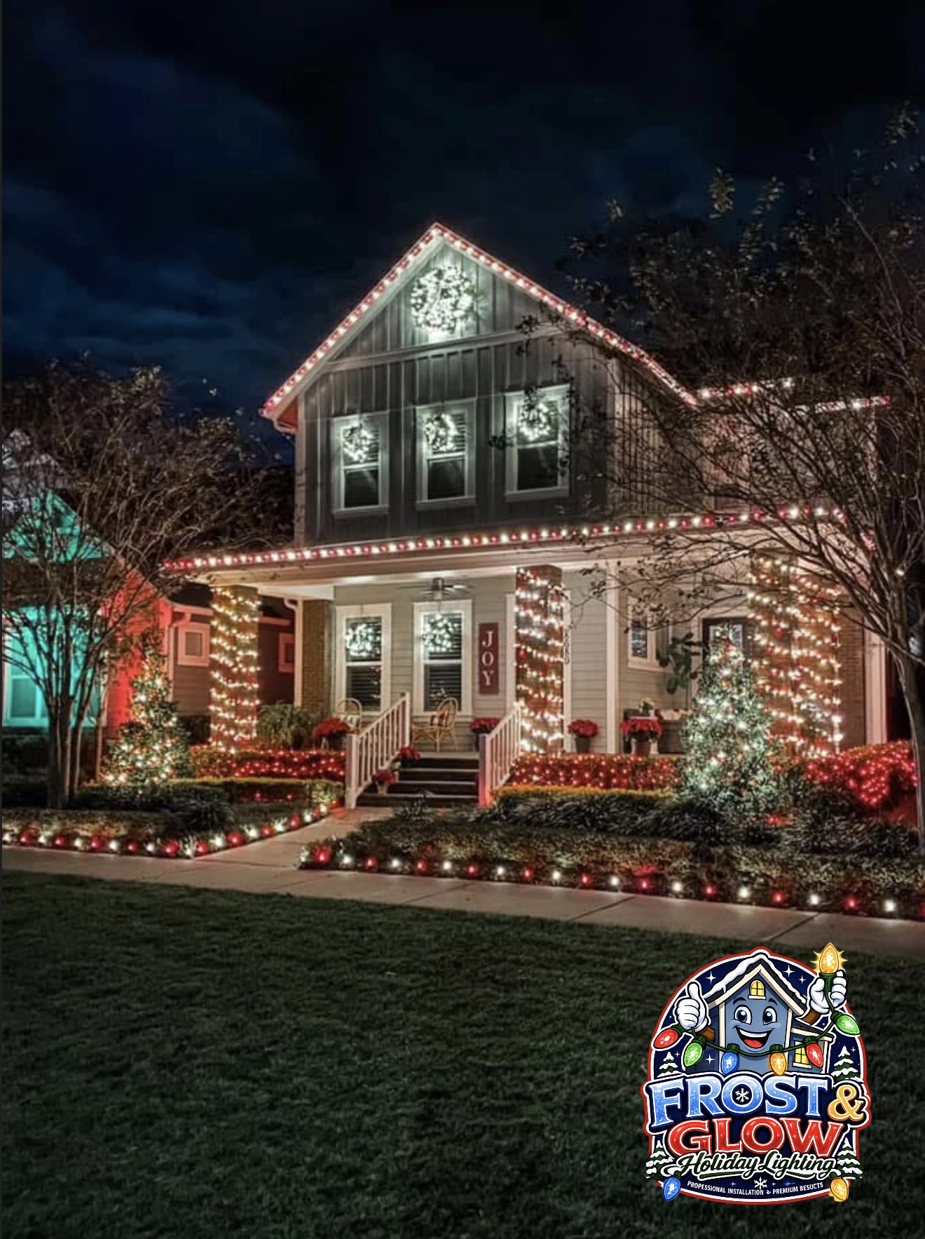 Alternating red and warm-white C9s along every peak, with lit wreaths in the windows and wrapped porch columns.